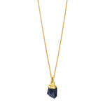 A raw Sapphire pendant electroplated in gold, hanging from a gold cable chain.
